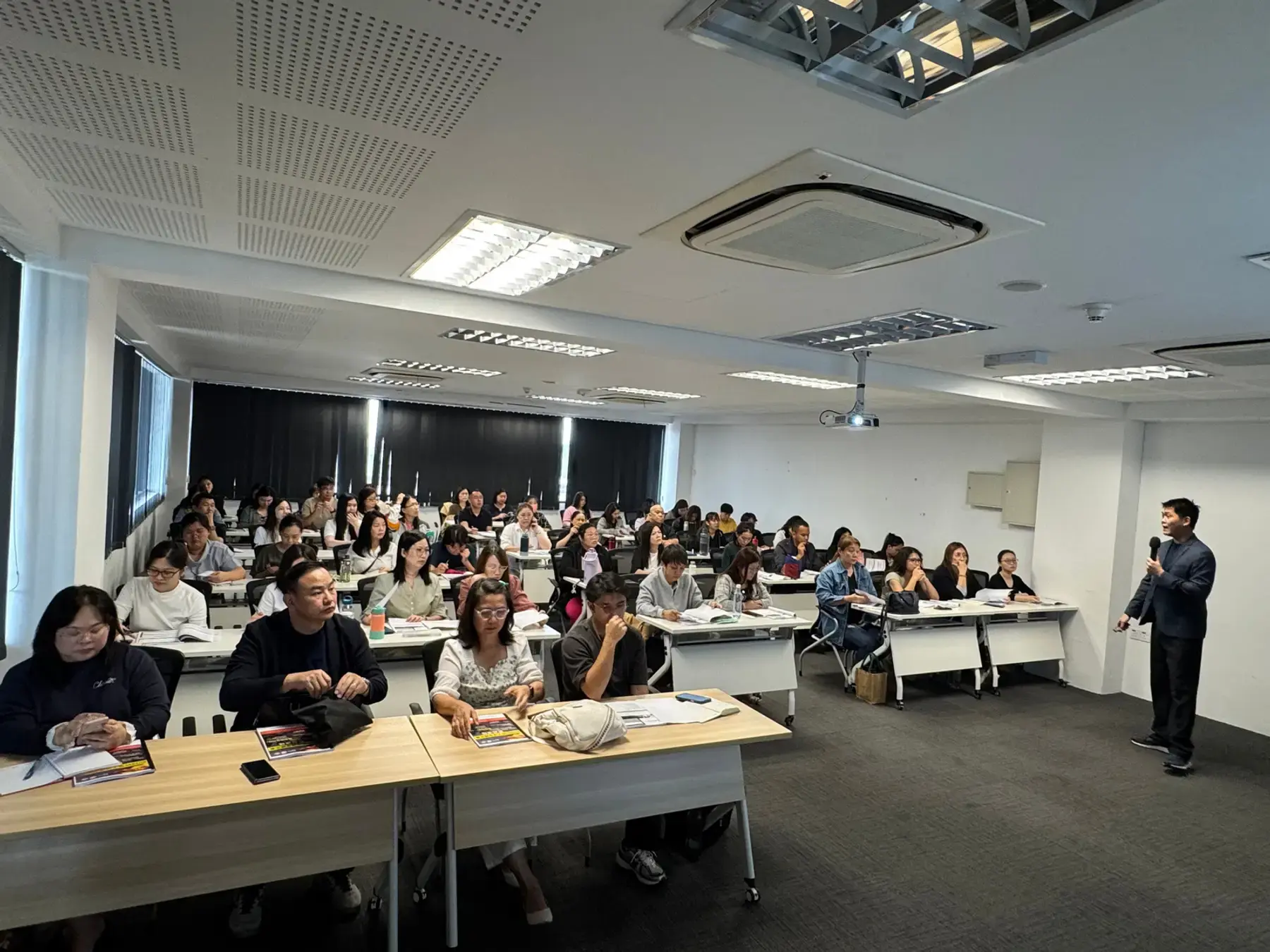 A trainer speaking to participants seated at desks