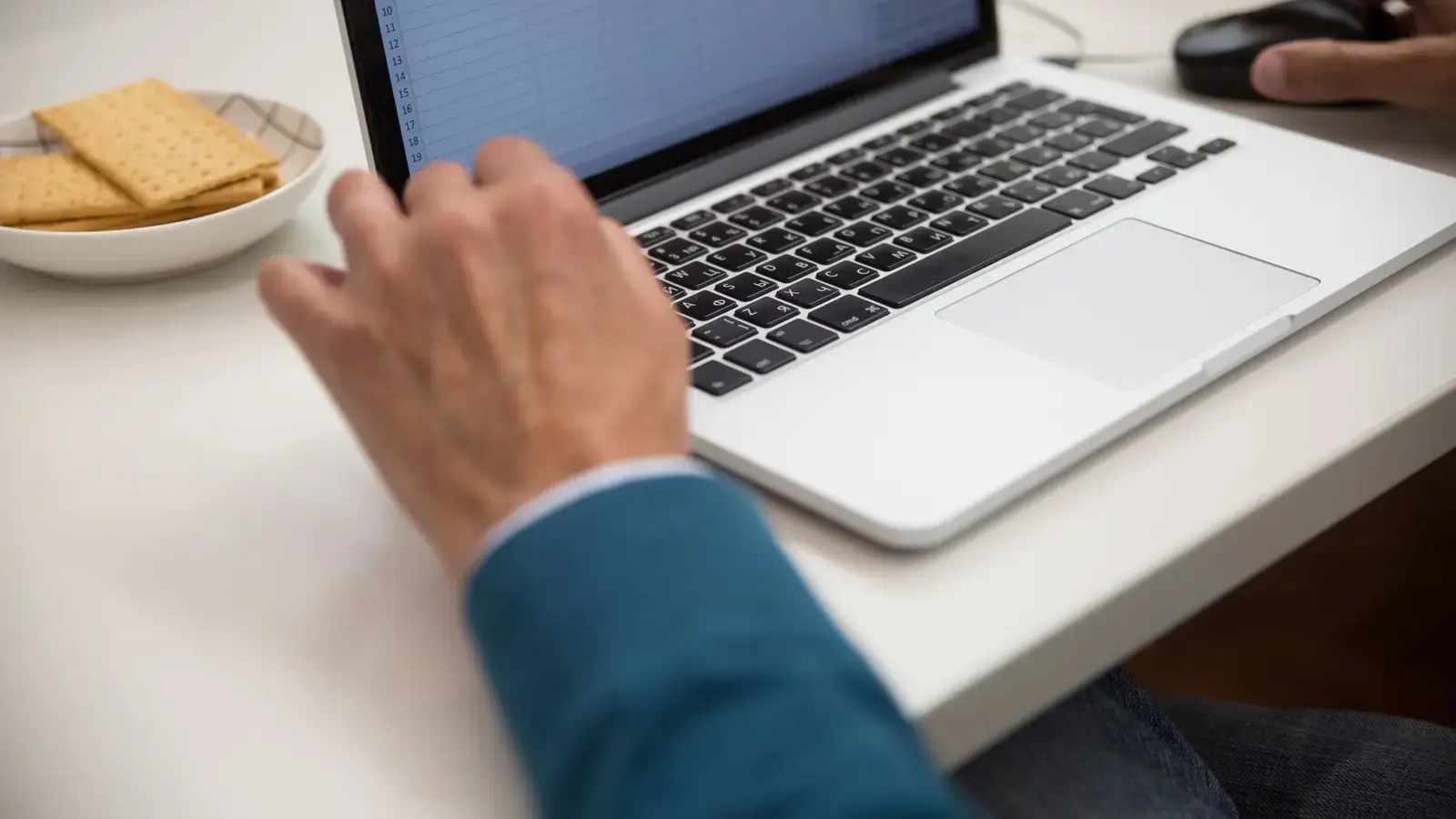Hands working on a laptop at a desk
